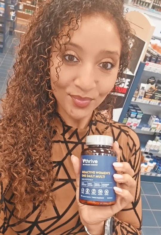a women showing Vthrive Bioactive Women's one daily multi